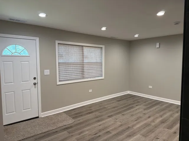 en empty room with wooden floor and windows