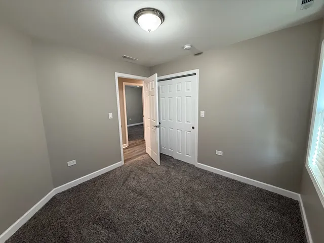 an empty room with closet and mirror