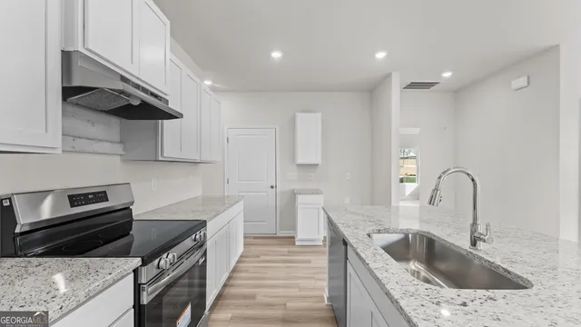 a kitchen with stainless steel appliances granite countertop a sink a stove and a refrigerator