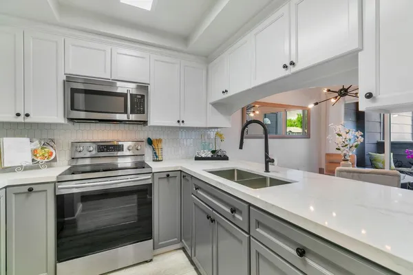 a kitchen with white cabinets and stainless steel appliances