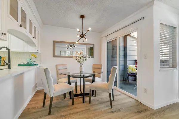 a dining room with furniture a chandelier and wooden floor