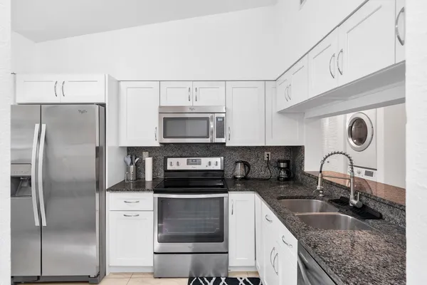 a kitchen with stainless steel appliances granite countertop a sink stove and refrigerator