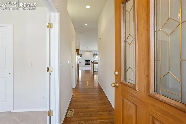 a view of a hallway with wooden floor and staircase