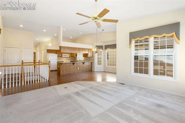 a view of an empty room with a fireplace and a window