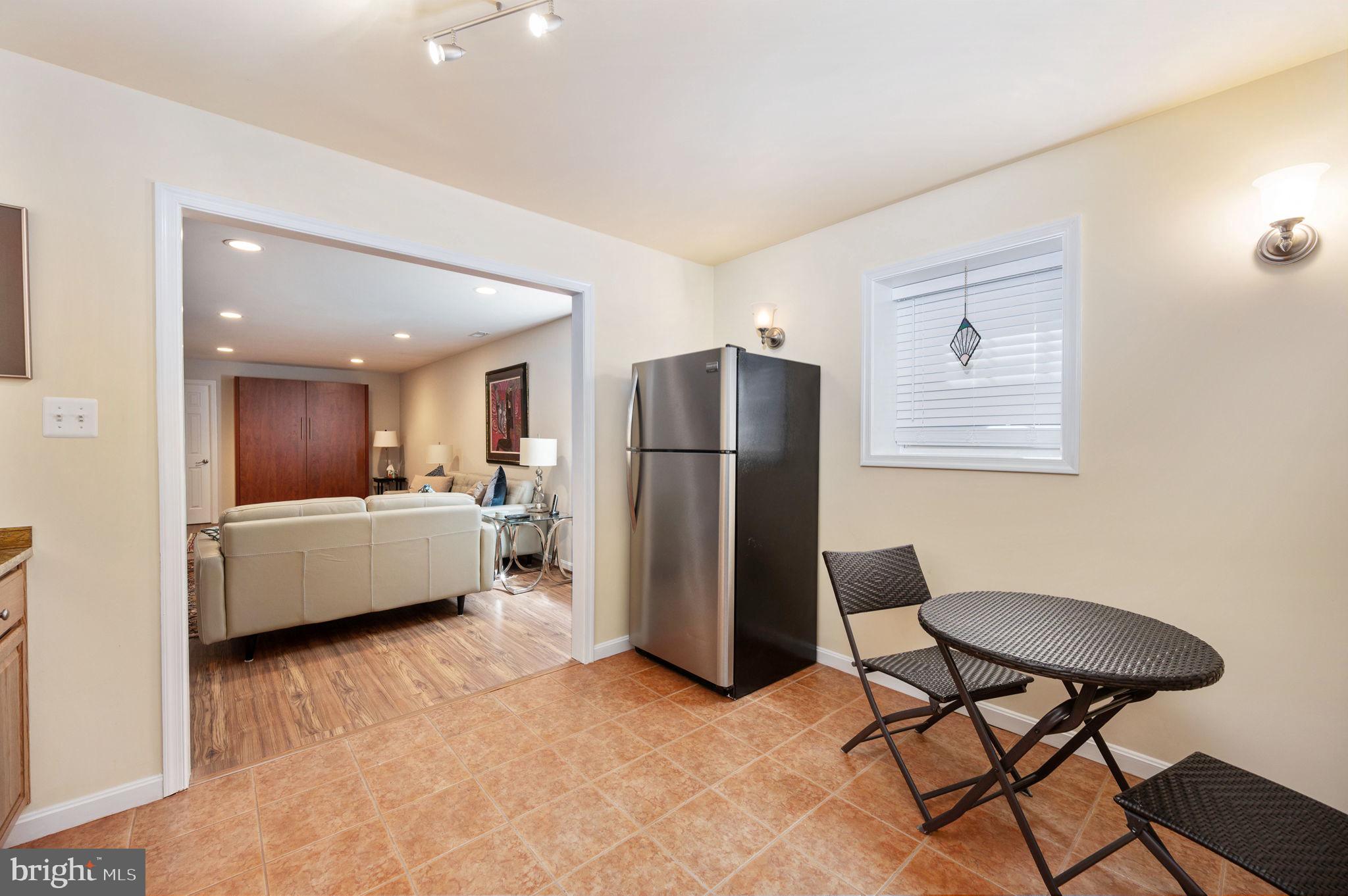 13700 Fieldstone Way Gainesville, VA 20155 - Photo 41 of 53 a living room with a couch a dining table and a refrigerator