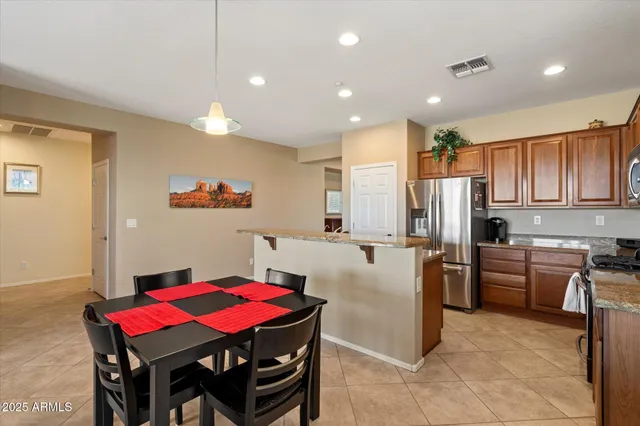a kitchen with stainless steel appliances kitchen island granite countertop a dining table and chairs