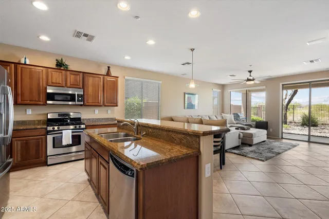 a kitchen with kitchen island granite countertop a sink counter top space appliances and a window