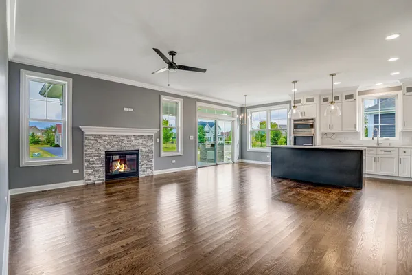 a view of a big room with wooden floor and a kitchen