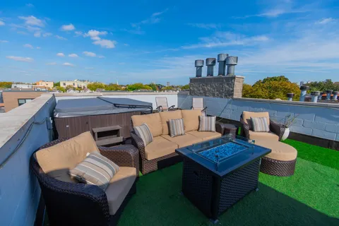 a view of roof deck with furniture and a garden