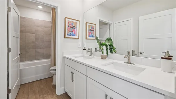a bathroom with a bathtub shower sink and mirror