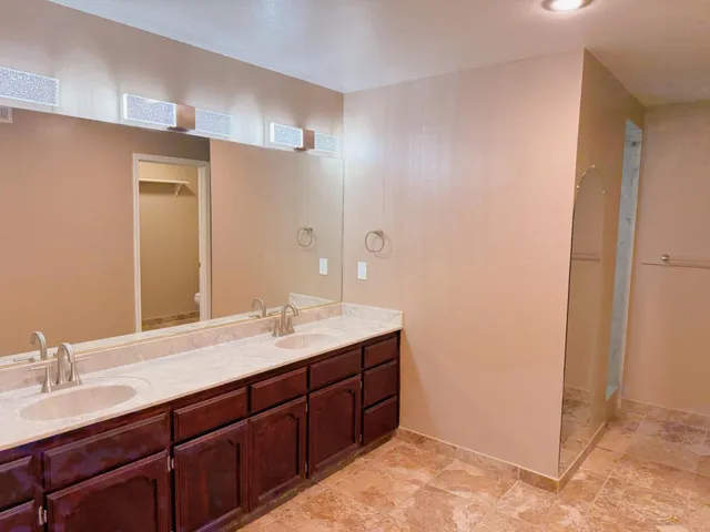 a bathroom with a granite countertop sink and a mirror