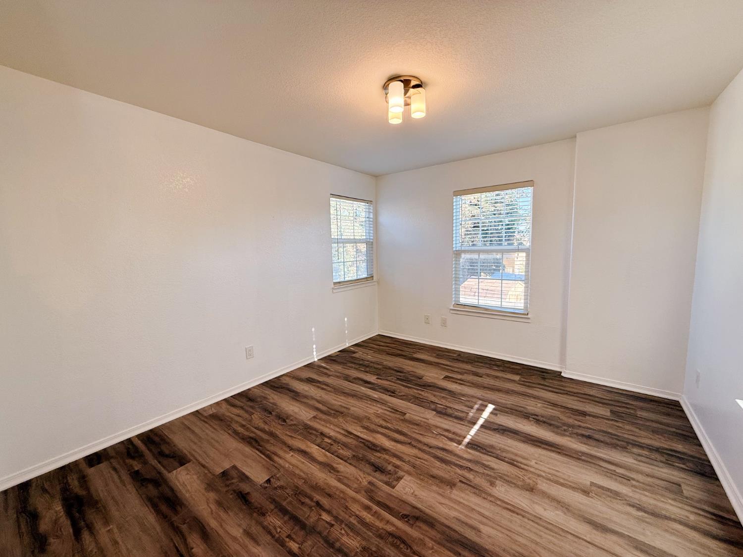 3147 Boulder Avenue Madera, CA 93637 - Photo 18 of 25 a view of an empty room with wooden floor and a window