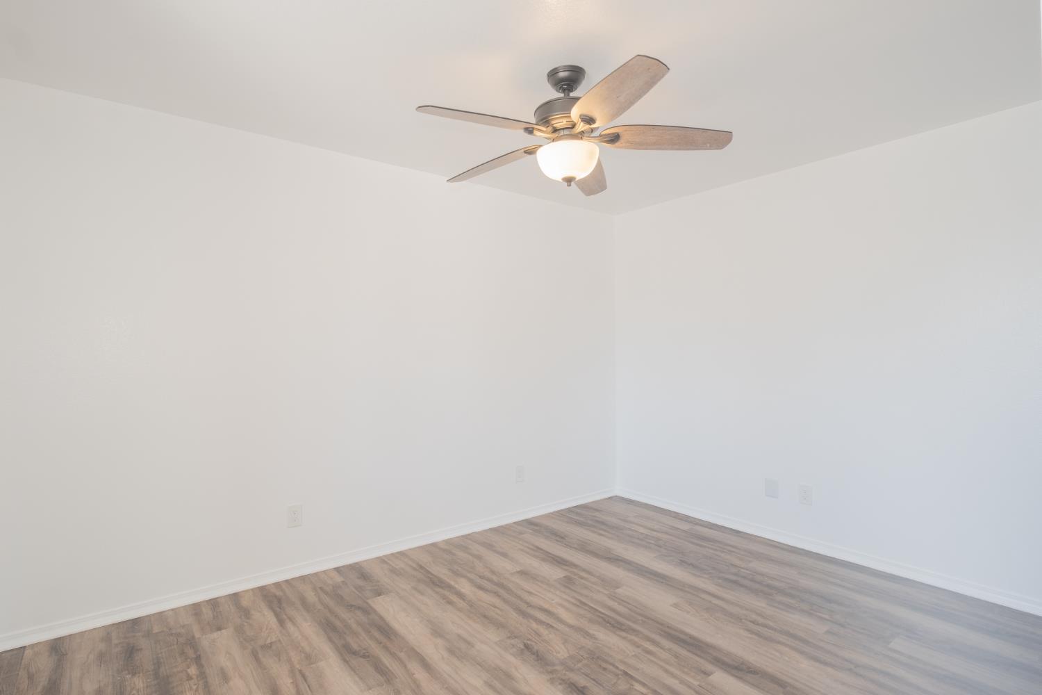 3147 Boulder Avenue Madera, CA 93637 - Photo 21 of 29 a view of a room with wooden floor and a ceiling fan