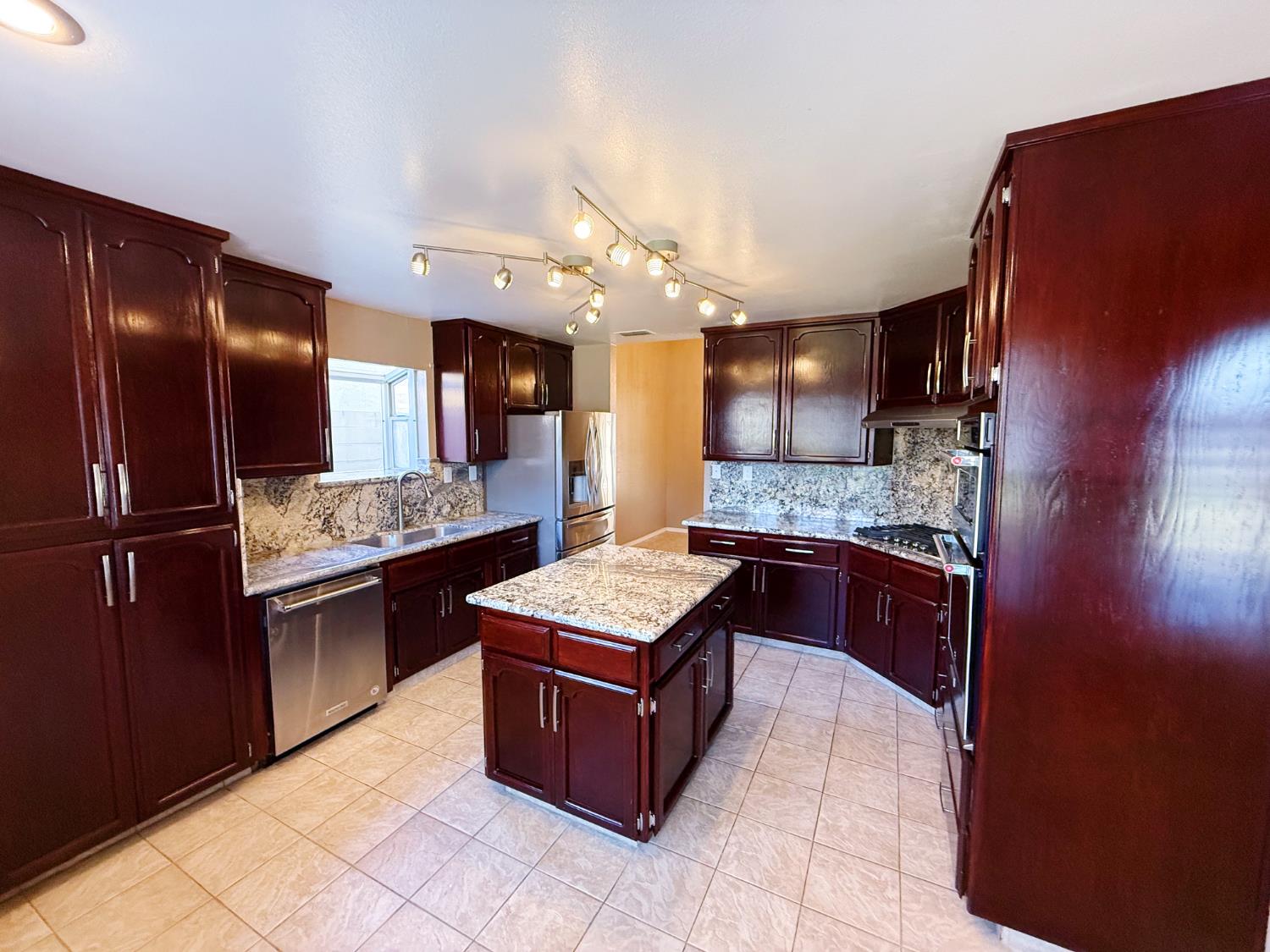 3147 Boulder Avenue Madera, CA 93637 - Photo 6 of 25 a kitchen with stainless steel appliances granite countertop a refrigerator and a stove
