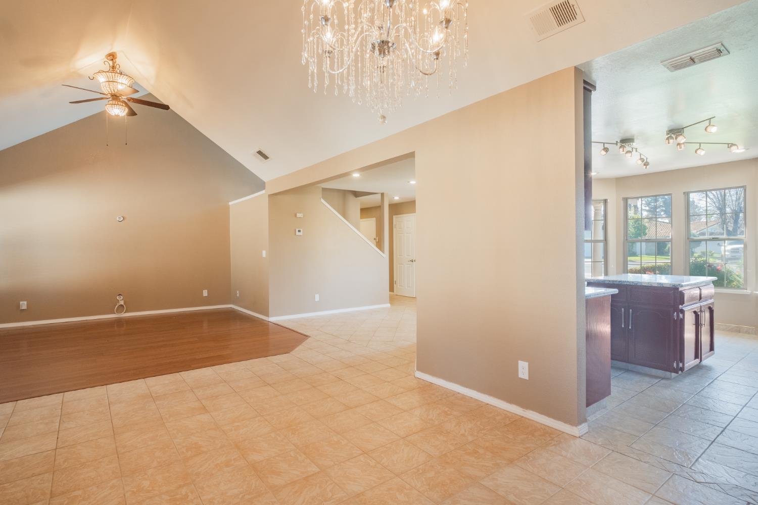 3147 Boulder Avenue Madera, CA 93637 - Photo 7 of 29 an empty room with a chandelier fan and windows
