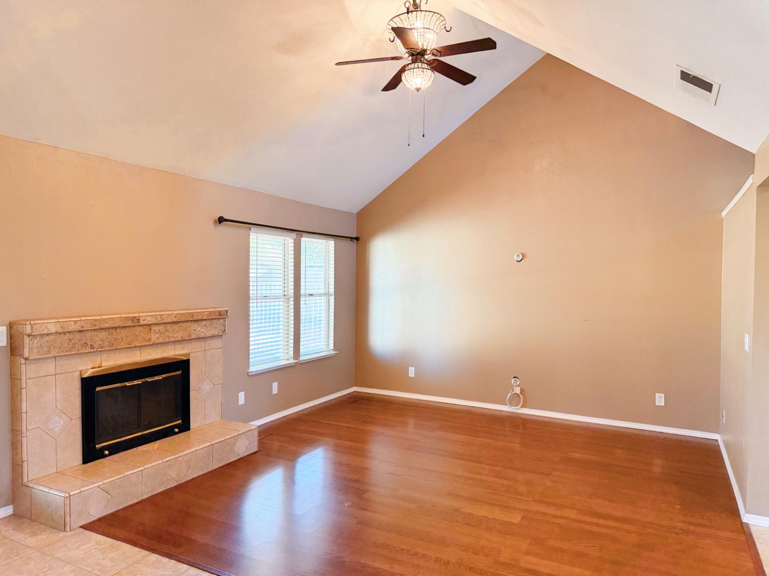 3147 Boulder Avenue Madera, CA 93637 - Photo 8 of 25 a view of empty room with wooden floor and fireplace