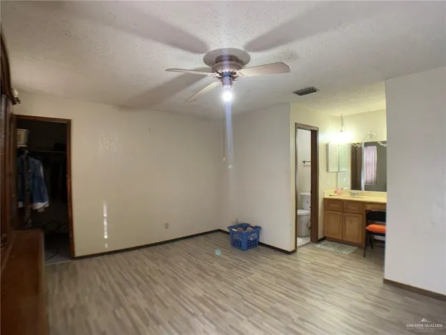 a view of a room with wooden floor and ceiling fan