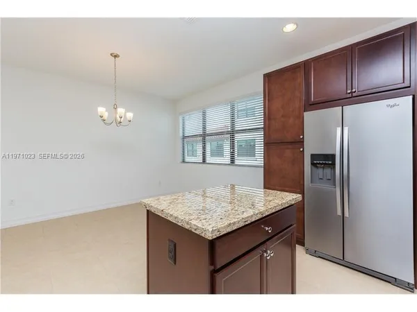 a kitchen with a sink refrigerator and cabinets