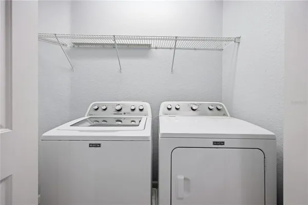 a view of a hallway with wooden floor and a bathroom