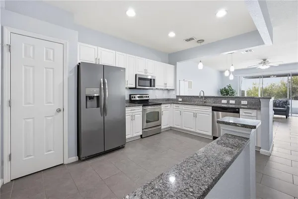 a kitchen with stainless steel appliances granite countertop a refrigerator sink and stove