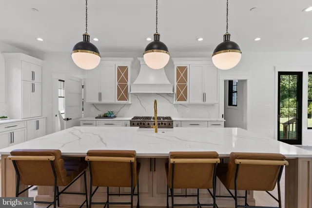 a kitchen with stainless steel appliances granite countertop a stove a sink and a chandelier