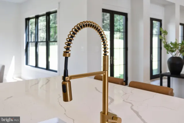 a view of a dining room and livingroom with furniture wooden floor a chandelier