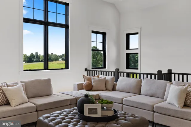 a view of a white house next to a yard with plants and trees