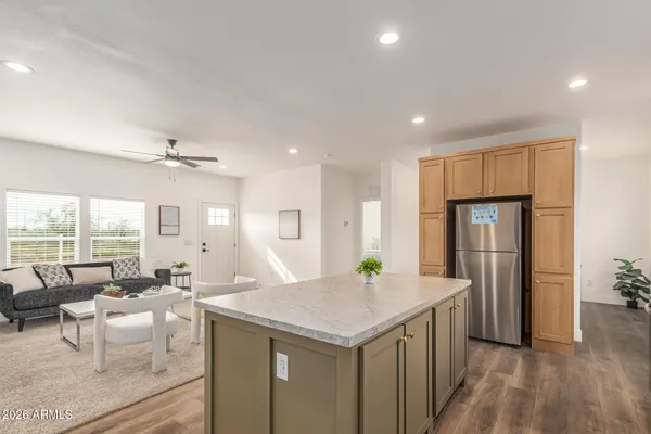 a kitchen with sink a refrigerator and chairs