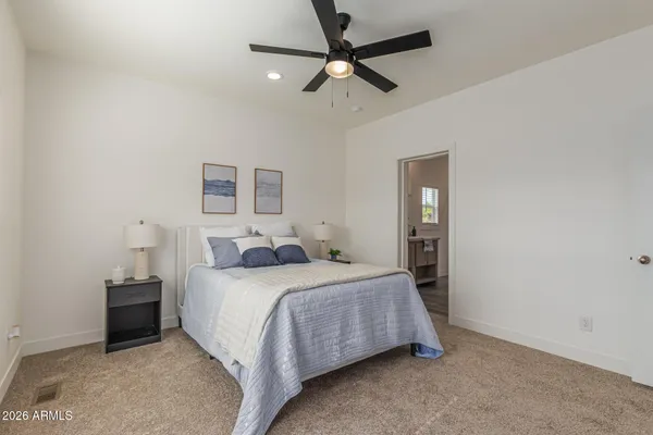 a bedroom with a bed a ceiling fan and a window