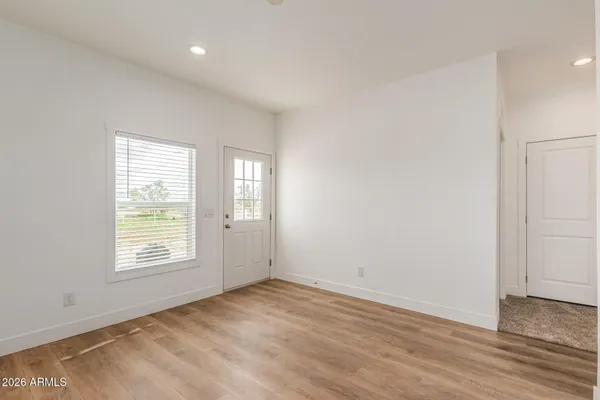 an empty room with wooden floor and windows