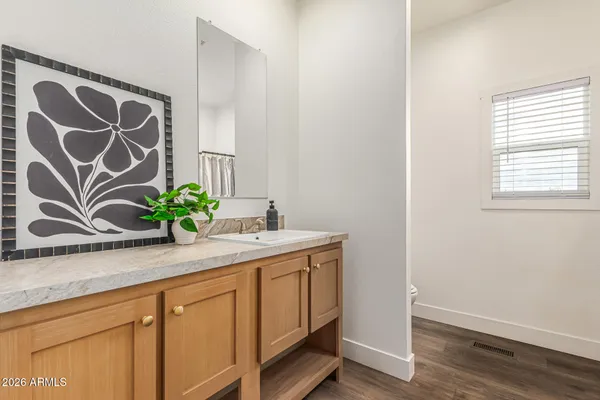 a bathroom with a granite countertop sink and a mirror