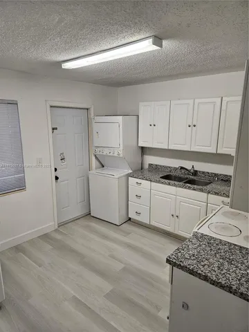 a kitchen with white cabinets and white appliances