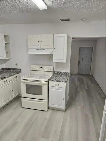 a kitchen with white cabinets and white appliances