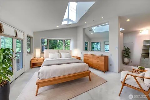 a bedroom with a bed and large windows