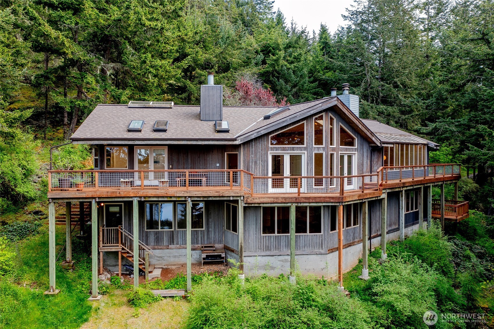 121 Switchback Road Orcas Island, WA 98245 - Photo 31 of 35 a aerial view of a house with a yard table and chairs under an umbrella