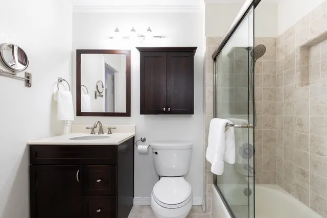 a bathroom with a toilet a sink a vanity and mirror