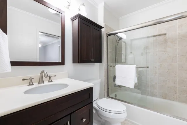 a bathroom with a sink a toilet a mirror a vanity and shower
