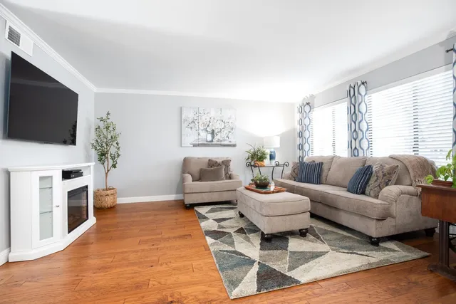 a living room with furniture a flat screen tv and a fireplace