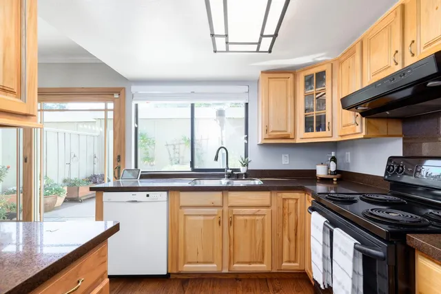 a kitchen with stainless steel appliances granite countertop a stove a sink and a microwave