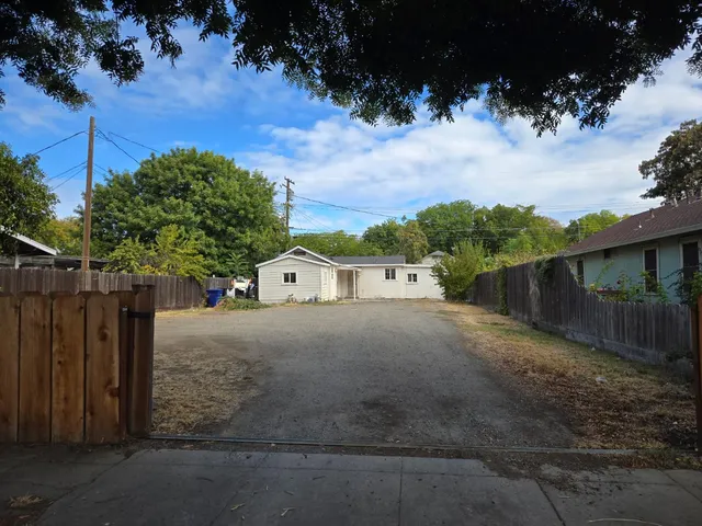 a view of a house with wooden fence next to a road