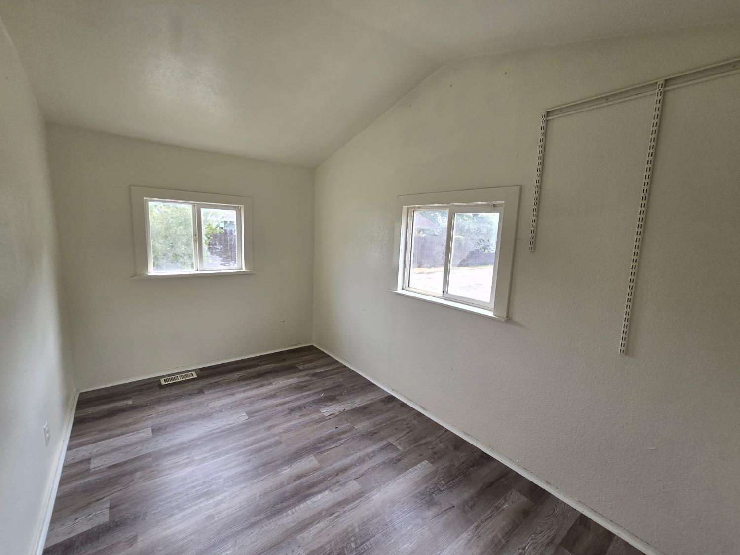 334 Semple Street Modesto, CA 95354 - Photo 17 of 28 an empty room with wooden floor and windows