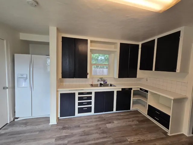 a view of a kitchen with wooden floor and electronic appliances