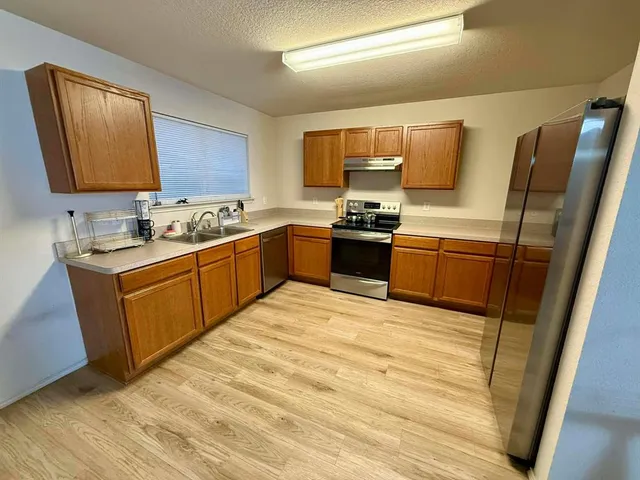a kitchen with stainless steel appliances granite countertop a sink stove and refrigerator