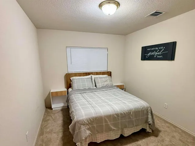 a bedroom with a bed and a wall painting