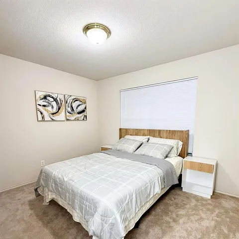 a bedroom with a bed and a night stand