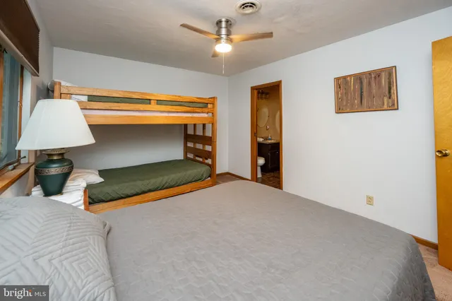 a bedroom with a bed and a ceiling fan