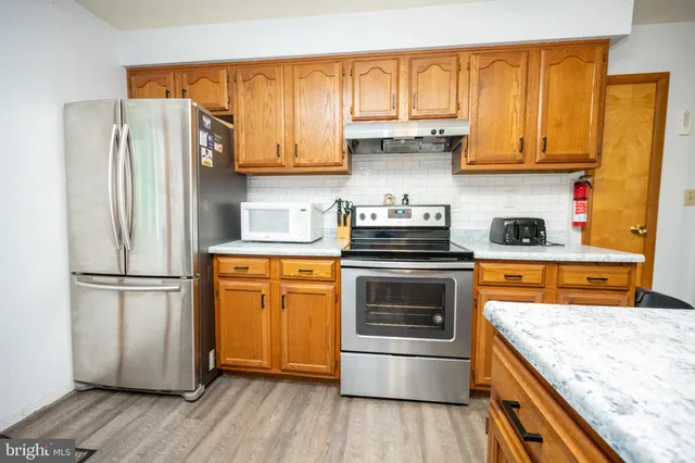 a kitchen with stainless steel appliances granite countertop a sink a stove a refrigerator and island