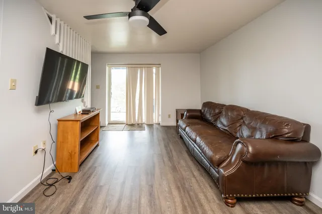 a living room with furniture a rug and wooden floor