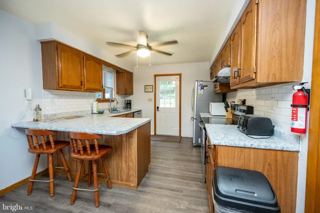 a kitchen with stainless steel appliances granite countertop a sink and cabinets with wooden floor
