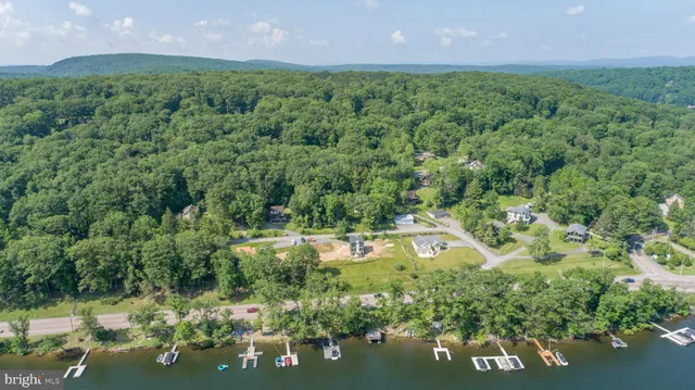 an aerial view of residential house with outdoor space and trees all around
